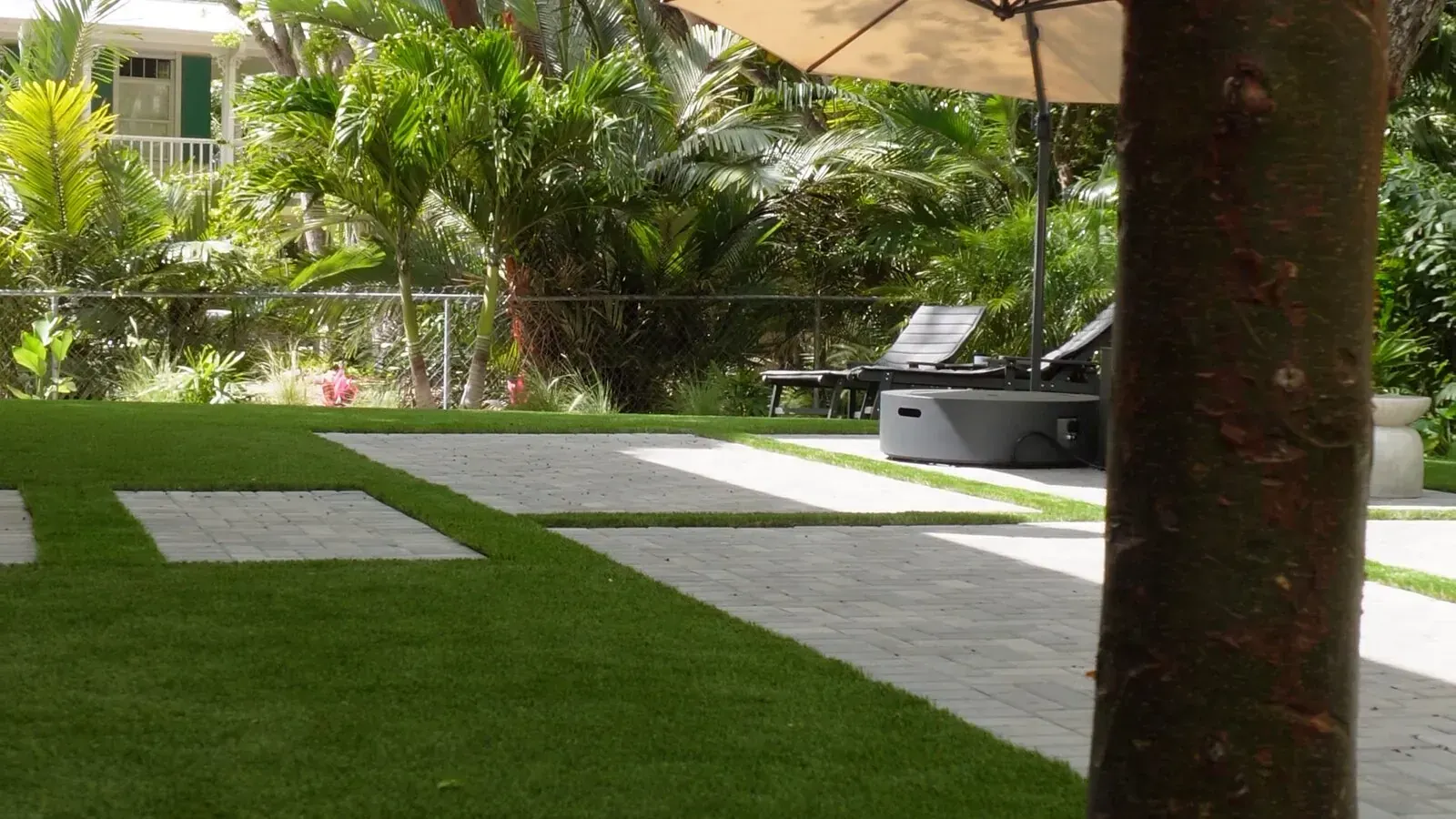 Finished backyard with turf, paver path and umbrella built by Keyscape