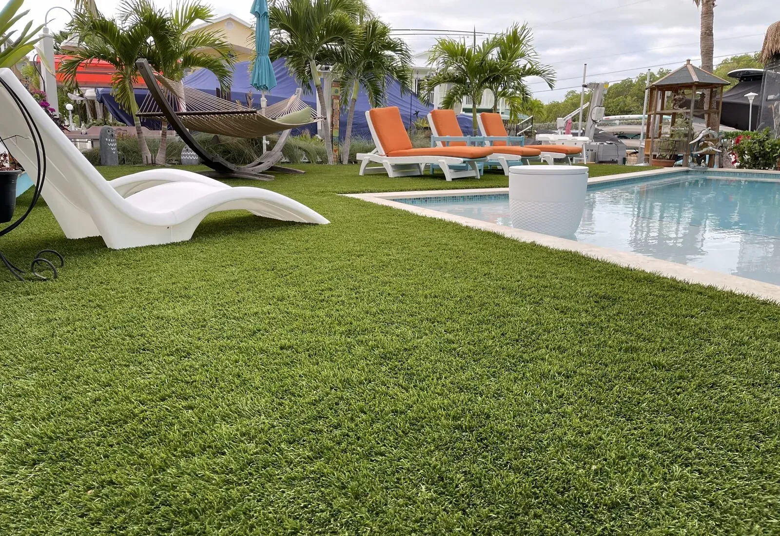 Lush artificial turf lawn beside a pool and lounge area in the Florida Keys