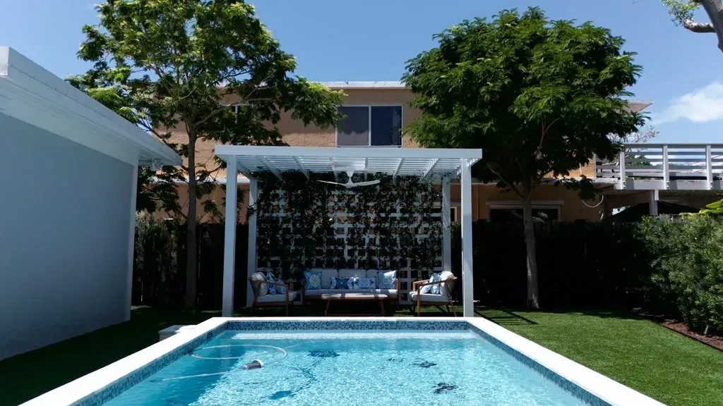 Palms framing a pool and pergola at a Florida Keys home landscaped by Keyscape
